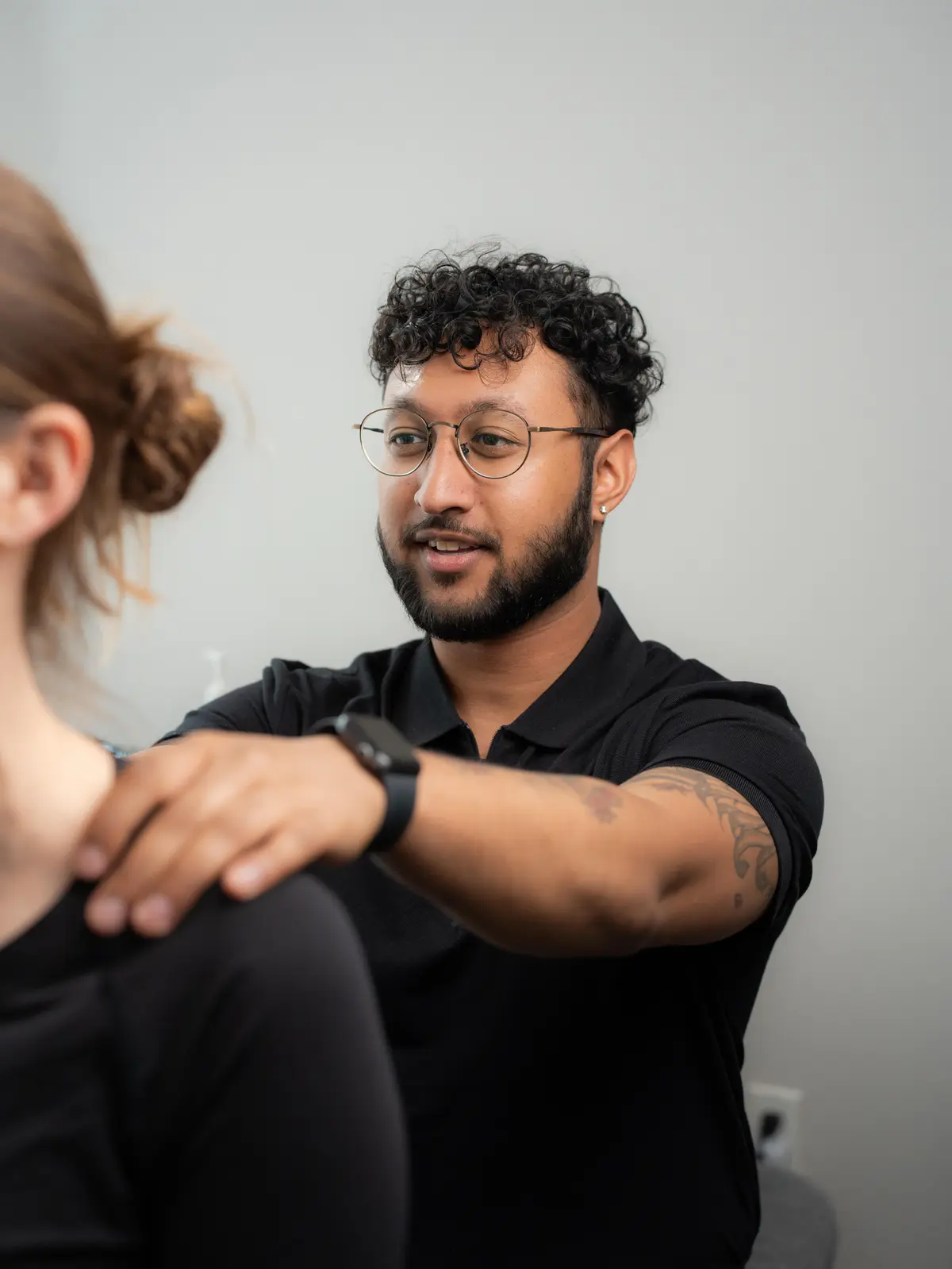 Kyle treating a patient's shoulder