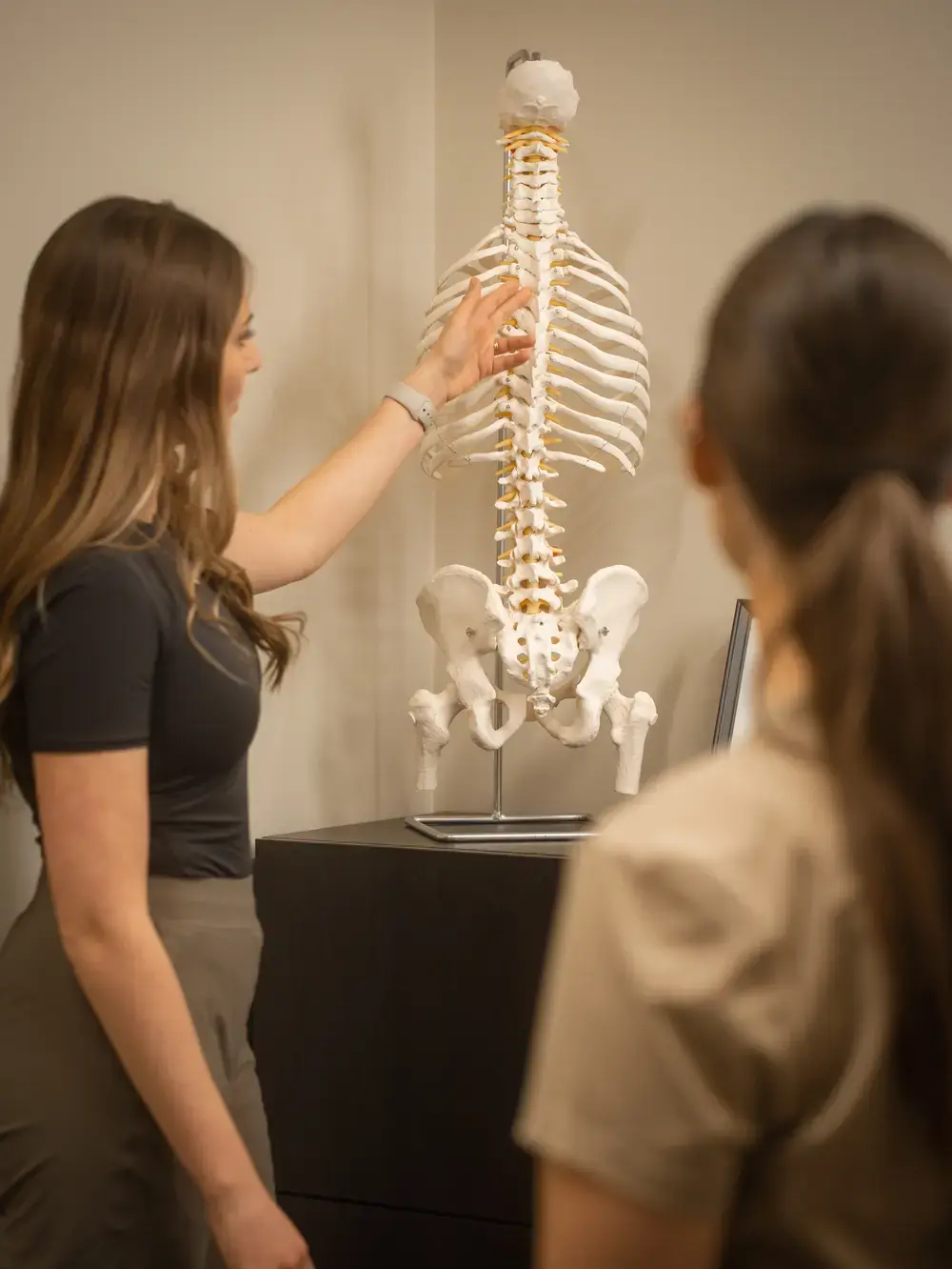 Paige explaining the spine model to a patient