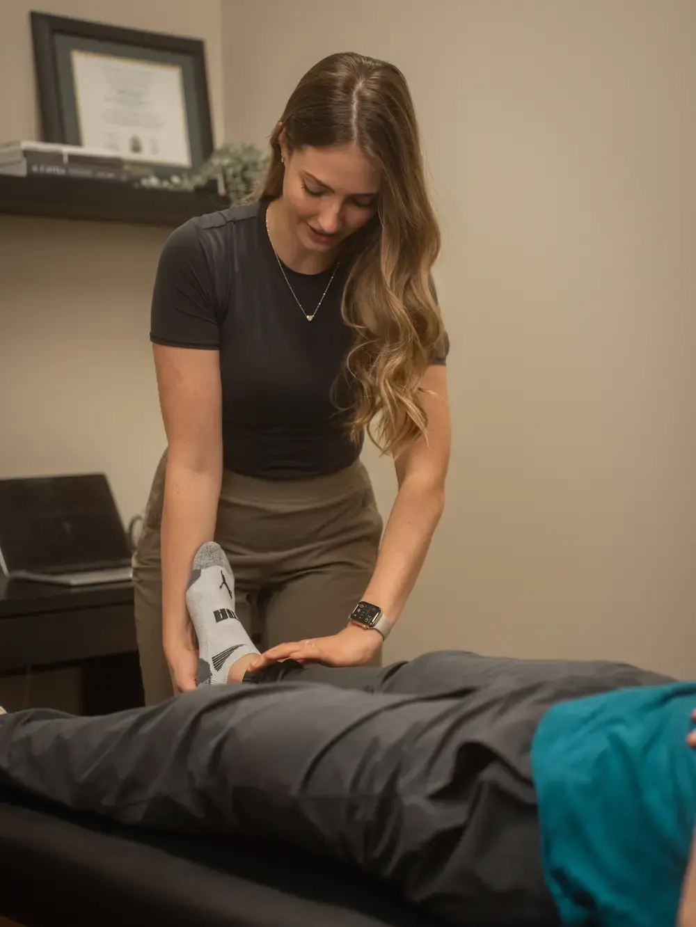 Paige Thomson in the clinic under the Edmonton Metro Osteopathic Clinic sign